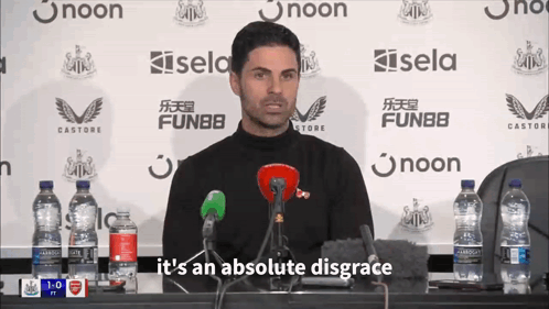 A Man Speaking Into A Microphone With The Words " It 'S An Absolute Disgrace " Below Him GIF