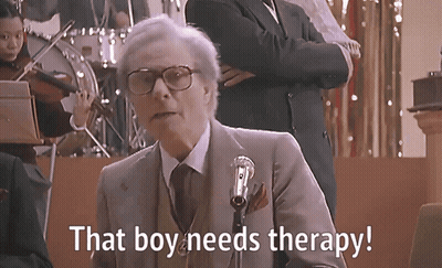 A Man Speaking Into A Microphone With The Words That Boy Needs Therapy Written Below Him GIF