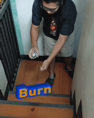 A Man Spray Paints A Blue Sign That Says Burn On A Set Of Stairs GIF