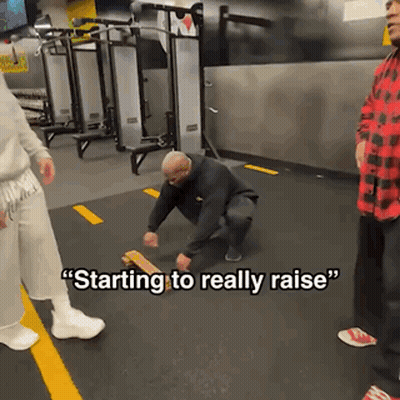A Man Squatting Down In A Gym With The Words " Starting To Really Raise " Written On The Floor GIF