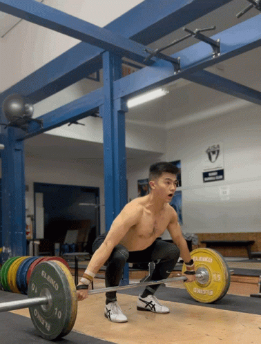A Man Squatting Down With A Barbell That Says Eleko GIF