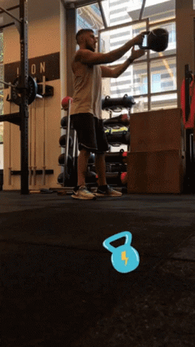 A Man Squatting In A Gym With A Sign On The Wall That Says Icon GIF