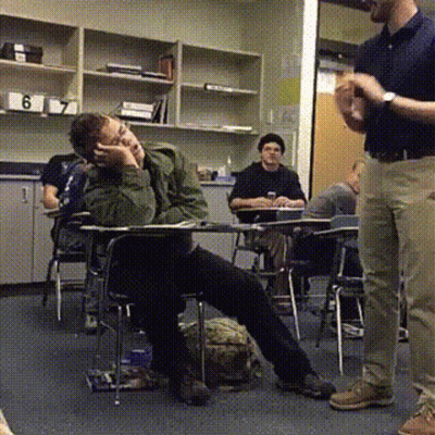 A Man Standing In A Classroom With The Number 6 On The Shelf GIF
