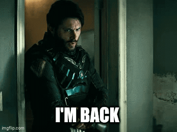 A Man Standing In A Doorway With The Words I 'M Back Written On The Bottom GIF