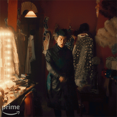 A Man Standing In A Dressing Room With The Words We Prime On The Bottom GIF
