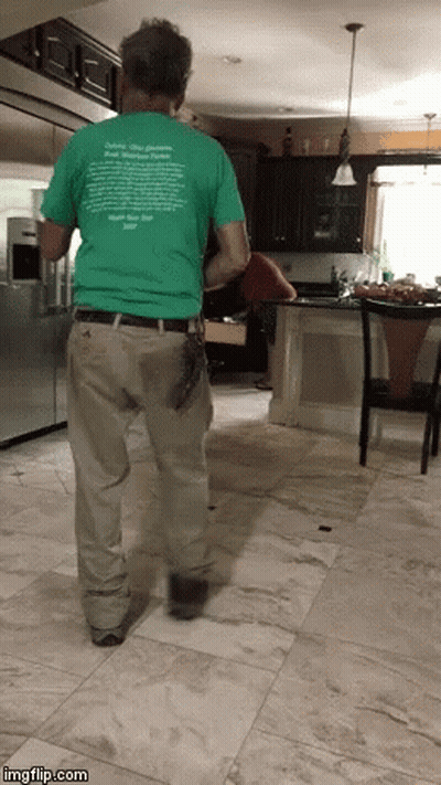 A Man Standing In A Kitchen Wearing A Green T-Shirt That Says " Delete Your Problems " On It GIF