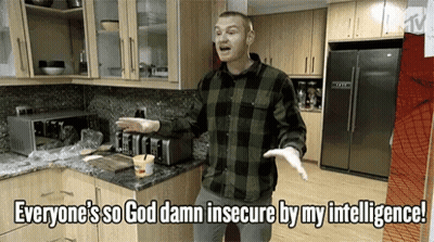 A Man Standing In A Kitchen With The Words Everyone 'S So God Damn Insecure By My Intelligence Above Him GIF