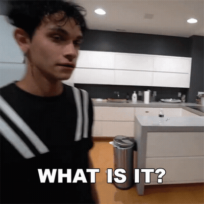 A Man Standing In A Kitchen With The Words What Is It Written On The Bottom GIF