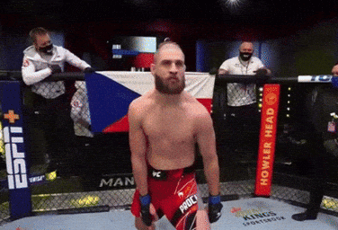 A Man Standing In A Ring With A Sign That Says Howler Head GIF