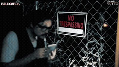 A Man Standing In Front Of A Barbed Wire Fence With A Sign That Says Sing On It GIF