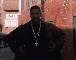 A Man Standing In Front Of A Brick Building That Says Carnic GIF