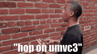A Man Standing In Front Of A Brick Wall With The Words " Hop On Umvc3 " On The Bottom GIF