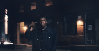 A Man Standing In Front Of A Building With A Sign That Says ' No Parking ' GIF