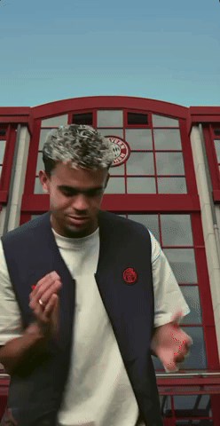 A Man Standing In Front Of A Building With A Sticker On It That Says ' Ucla ' GIF
