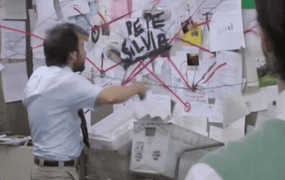 A Man Standing In Front Of A Bulletin Board That Says " Pepe Silvia " GIF