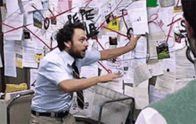 A Man Standing In Front Of A Bulletin Board With Papers On It Including One That Says Pepe GIF