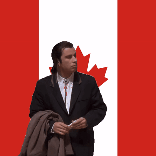 A Man Standing In Front Of A Canadian Flag With A Maple Leaf On It GIF