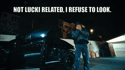 A Man Standing In Front Of A Car With The Words " Not Lucki Related I Refuse To Look " Above Him GIF