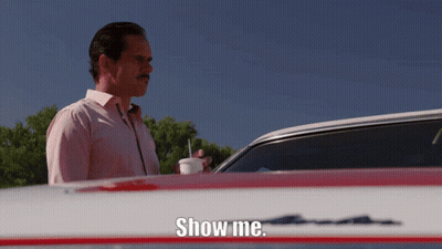 A Man Standing In Front Of A Car With The Words Show Me On The Hood GIF