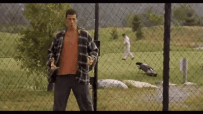 A Man Standing In Front Of A Chain Link Fence GIF