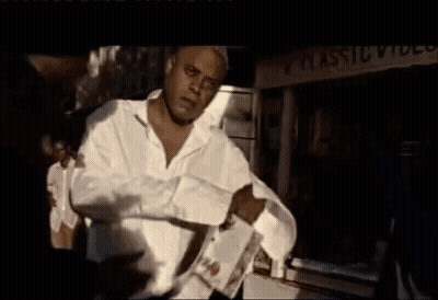 A Man Standing In Front Of A Classic Video Sign GIF