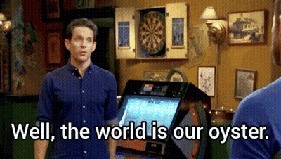 A Man Standing In Front Of A Dart Board With The Words Well The World Is Our Oyster GIF