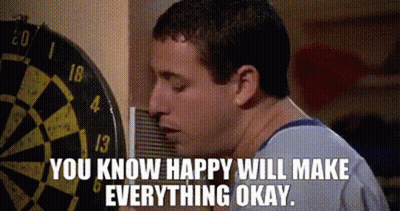 A Man Standing In Front Of A Dart Board With The Words " You Know Happy Will Make Everything Okay " Written Below Him GIF