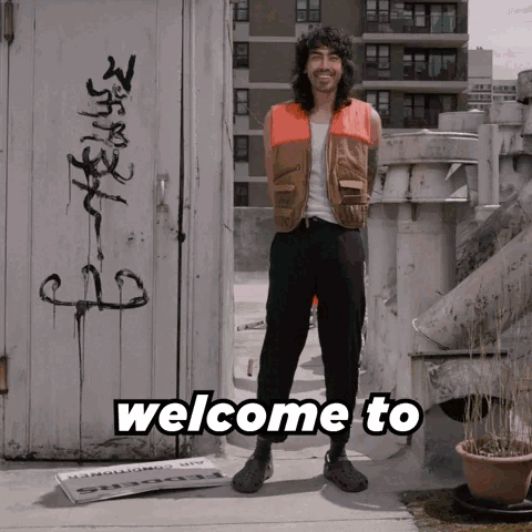 A Man Standing In Front Of A Door That Says Welcome To On It GIF