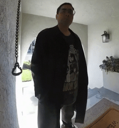 A Man Standing In Front Of A Door Wearing A Shirt That Says Monsoon GIF