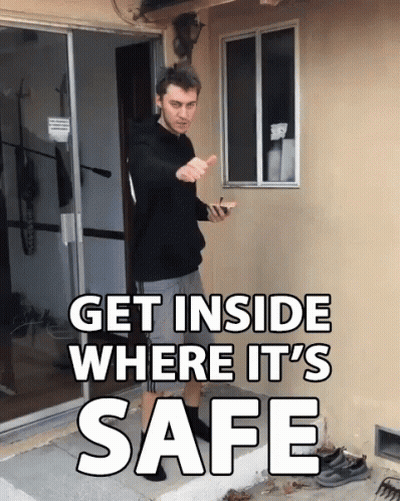 A Man Standing In Front Of A Door With The Words Get Inside Where It 'S Safe Above Him GIF