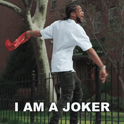 A Man Standing In Front Of A Fence With The Words " I Am A Joker " GIF