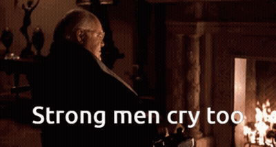 A Man Standing In Front Of A Fireplace With The Words Strong Men Cry Too On The Bottom GIF