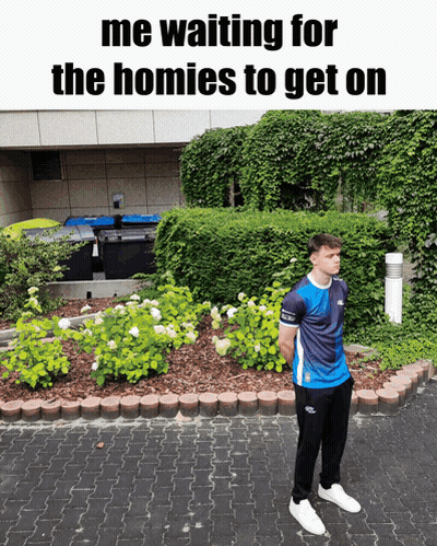 A Man Standing In Front Of A Garden With The Words " Me Waiting For The Homies To Get On " Above Him GIF