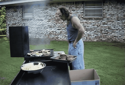 A Man Standing In Front Of A Grill With A Box In Front Of Him That Says " Fragile " GIF