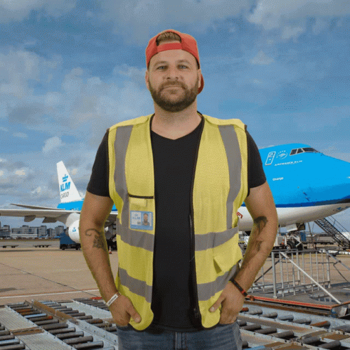 A Man Standing In Front Of A Klm Plane GIF