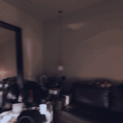 A Man Standing In Front Of A Large Mirror In A Dark Room GIF