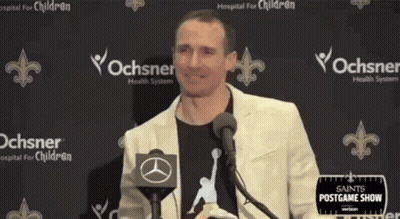 A Man Standing In Front Of A Microphone With His Arms Outstretched . GIF