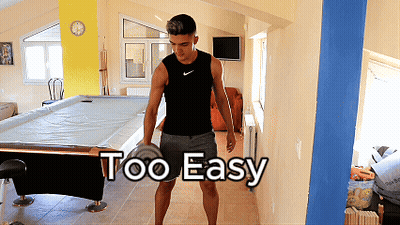 A Man Standing In Front Of A Pool Table With The Words Too Easy Written On The Wall GIF
