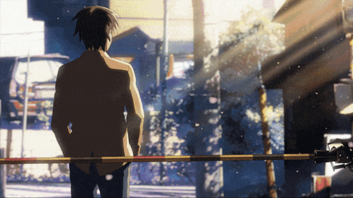 A Man Standing In Front Of A Railing With His Hands In His Pockets Looking At Something GIF
