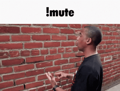 A Man Standing In Front Of A Red Brick Wall With The Words !Mute Above Him GIF