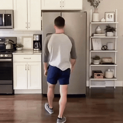 A Man Standing In Front Of A Refrigerator That Says ' Ice ' On It GIF