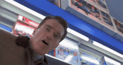 A Man Standing In Front Of A Shelf With A Sign That Says ' Coca-Cola ' On It GIF