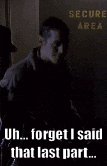 A Man Standing In Front Of A Sign That Says " Secure Area " GIF