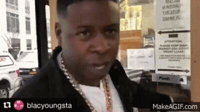 A Man Standing In Front Of A Sign That Says Waiting GIF