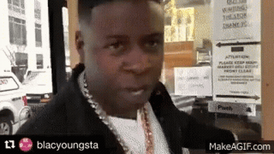 A Man Standing In Front Of A Sign That Says Waiting GIF