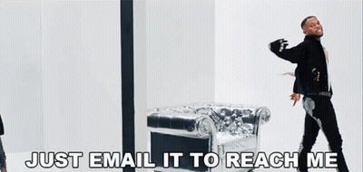 A Man Standing In Front Of A Silver Chair With The Words Just Email It To Reach Me GIF