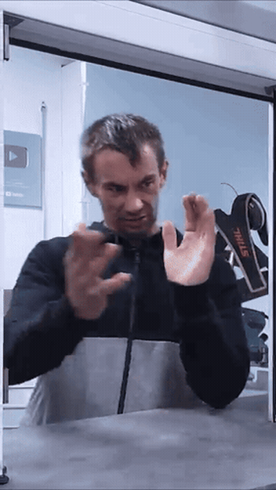 A Man Standing In Front Of A Stihl Sign GIF