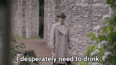 A Man Standing In Front Of A Stone Wall Says I Desperately Need To Drink GIF