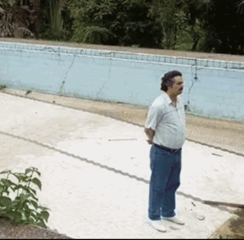 A Man Standing In Front Of A Swimming Pool GIF