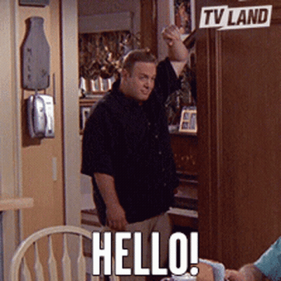 A Man Standing In Front Of A Tv Land Sign Says Hello GIF